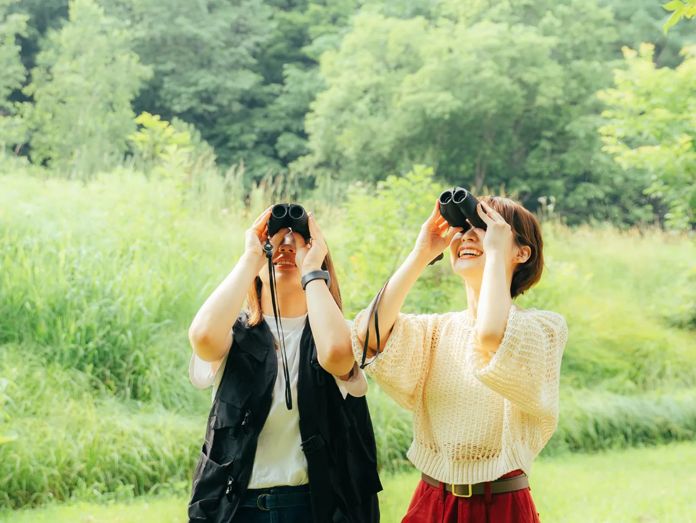 双眼鏡で自然観察をする2人の写真